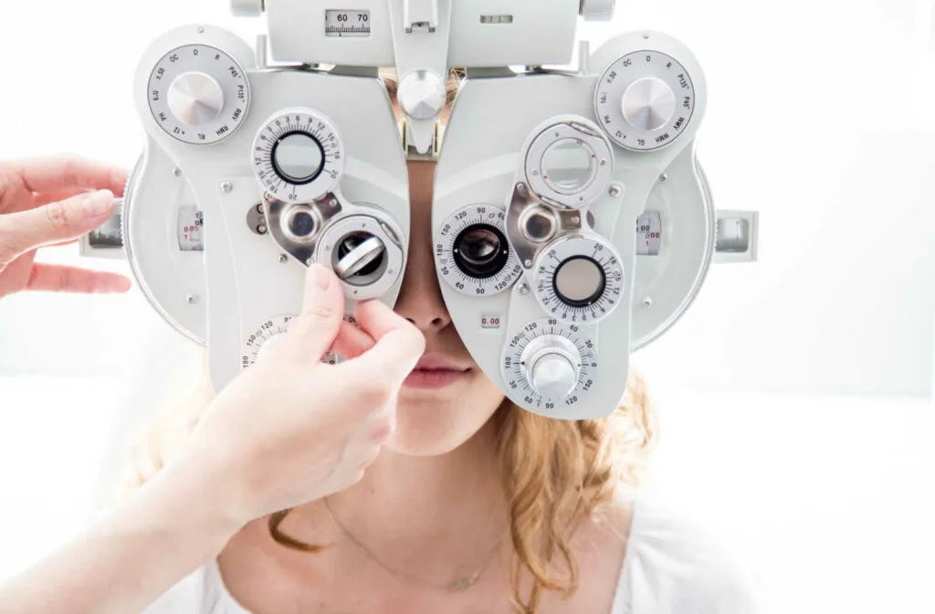 Patient looking through a phoropter while the doctor adjusts the lenses during a comprehensive eye exam