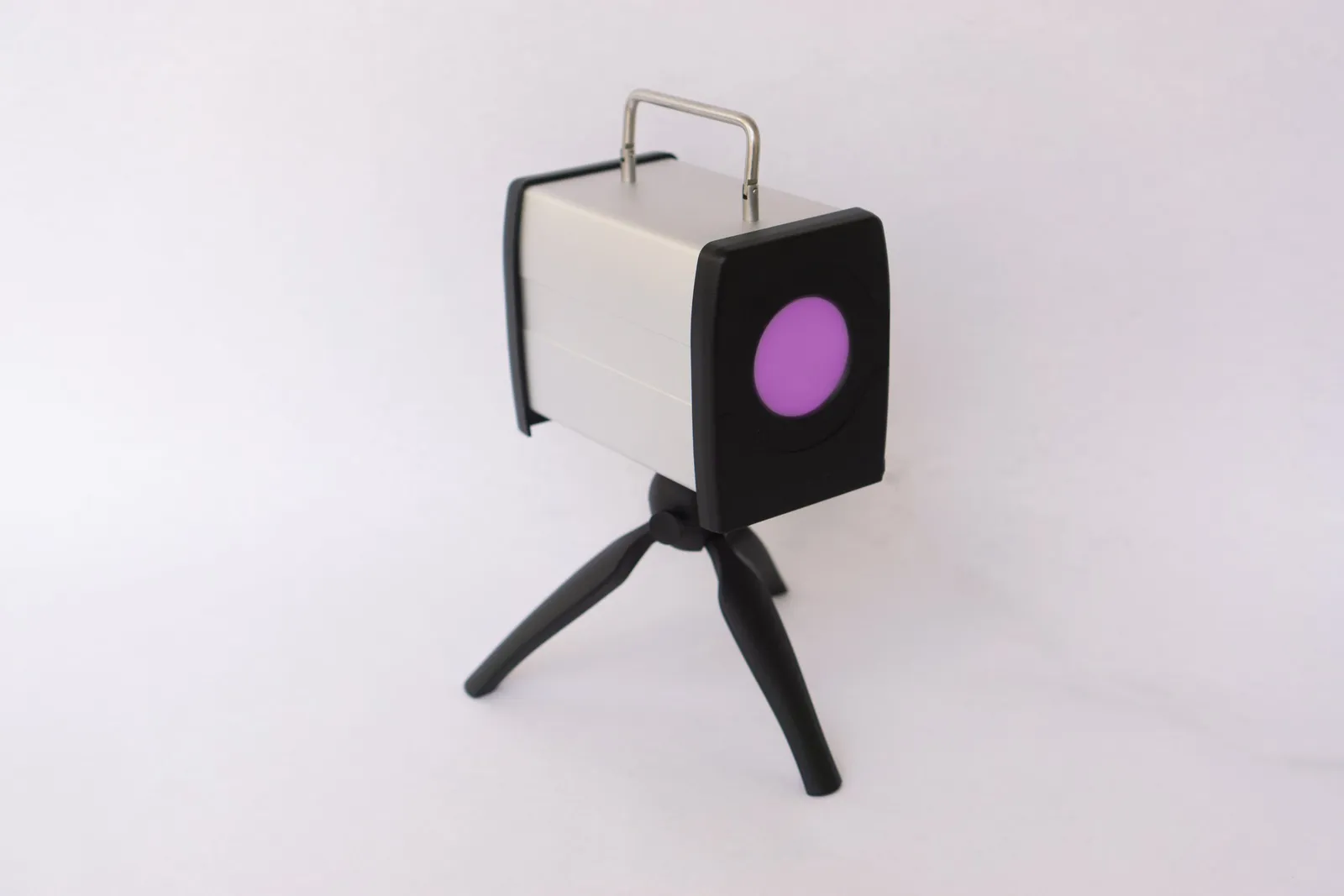 A tabletop syntonics instrument on a small tripod: a light source behind a round colored filter that the patient looks into during a session.