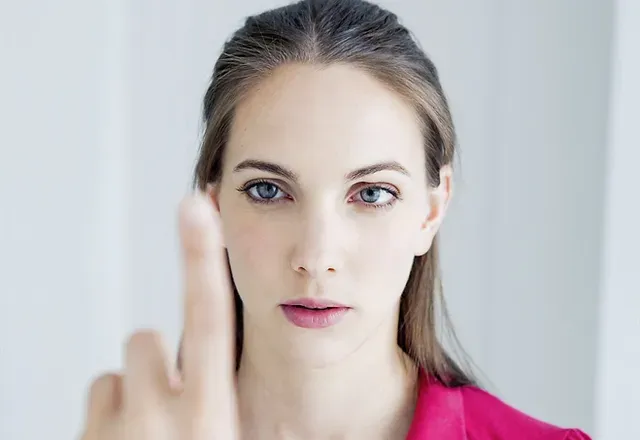 An adult woman follows a fingertip held close to her face during an eye teaming test
