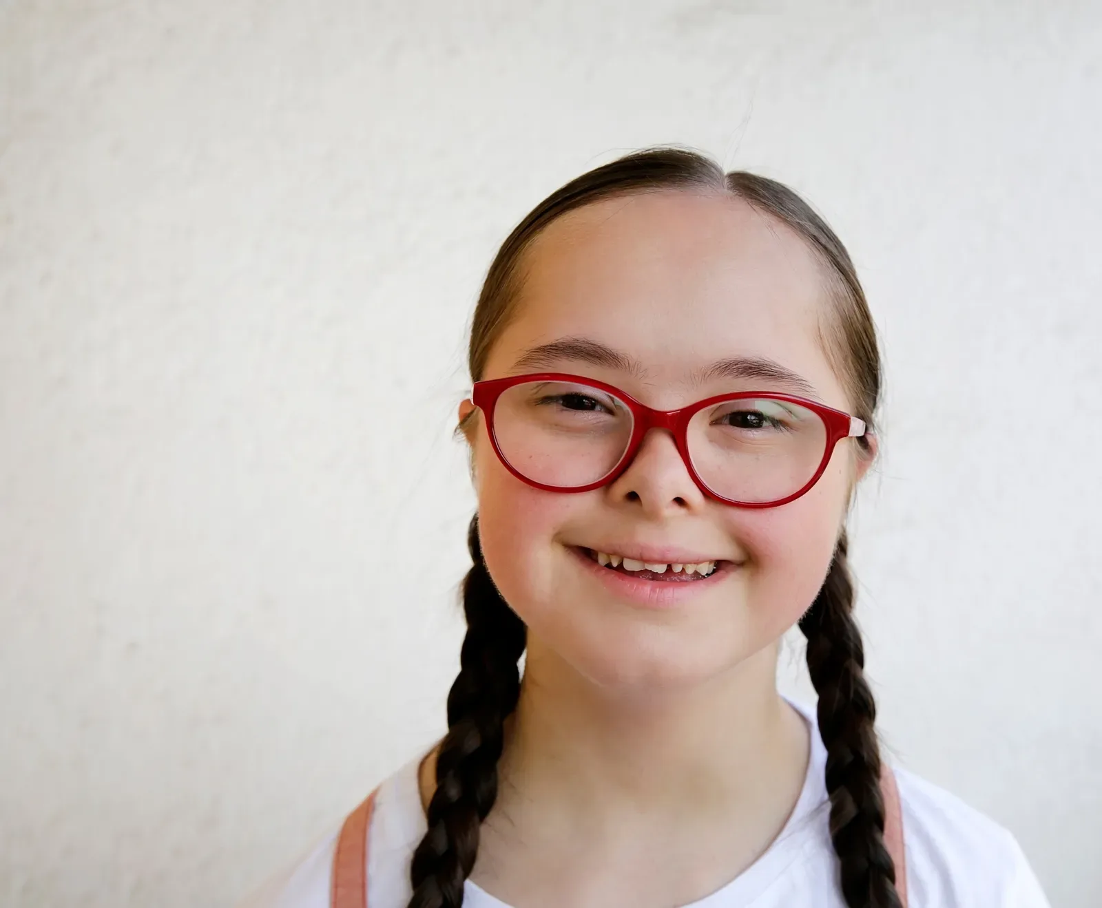 A smiling girl wearing red glasses