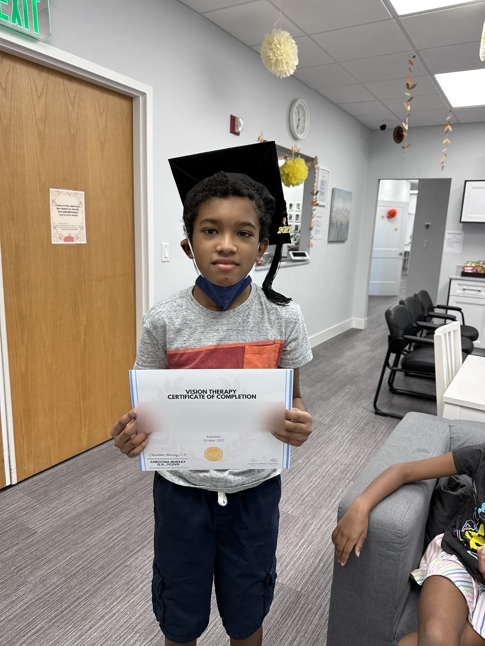 A vision therapy graduate holding their certificate
