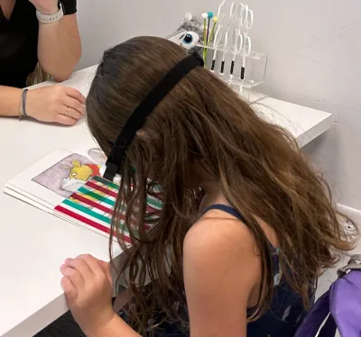 A child working through a visual-motor activity at a therapy table