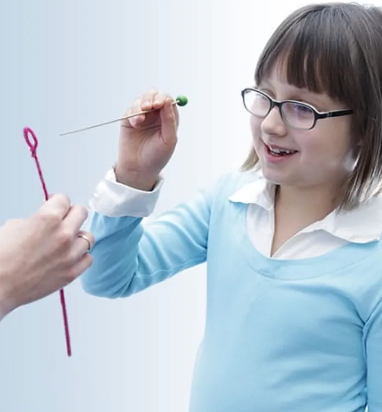 A child working through a home vision therapy activity at a table