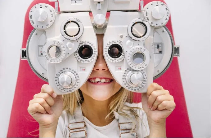 Child looking through a phoropter during a developmental vision evaluation