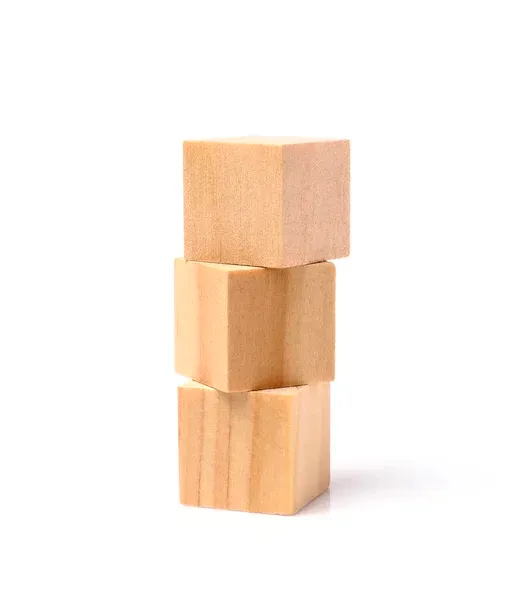 Three plain wooden cubes stacked into a small tower on a white background
